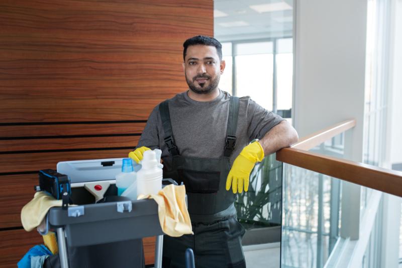 A janitor with a cleaning cart